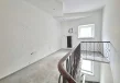 Antresola lokalu usługowego z metalową balustradą, oknem oraz schodami prowadzącymi na niższą kondygnację.