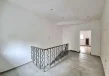 Antresola lokalu usługowego z metalową balustradą, oknem oraz schodami prowadzącymi na niższą kondygnację.